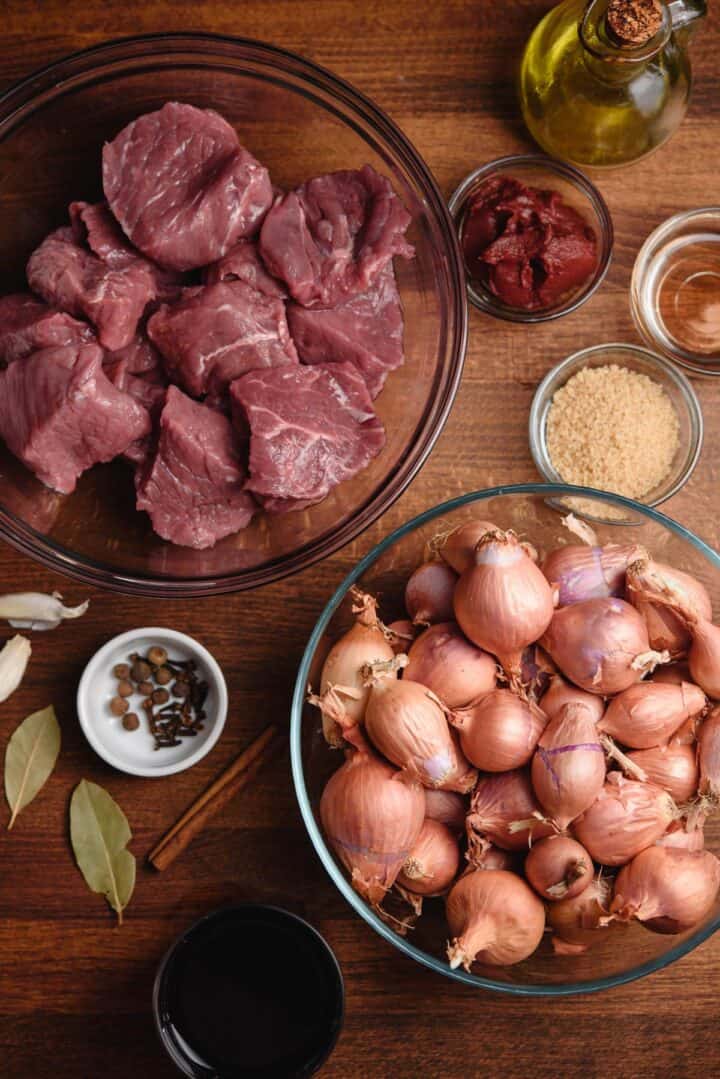 Greek Stifado ingredients on wooden cutting board